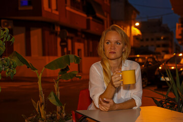 Pretty woman drinks tea or coffee in a cafe