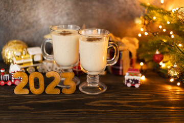 Traditional Christmas drink egg nog and wooden numbers 2023