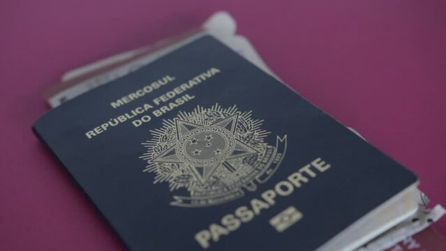 Brazilian passport is thrown on table with air tickets inside