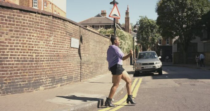 Dance, freedom and energy with black woman in street for passion, gen z and crazy in urban town. Music, happy and performance with girl dancing in road of city for celebration, creative and art