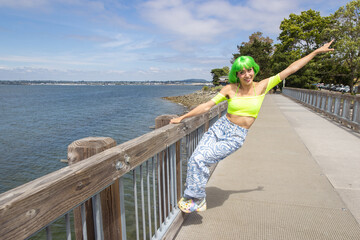 Asian woman with neon green hair having fun at a waterfront park outside in the sun