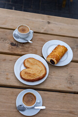 Top View of two Coffee Cups with 2 Bakery Goods on Wooden Table