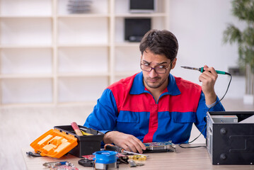 Young male repairman repairing computer