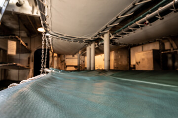 Inside the bunk cot on a dark room below deck on a ship.