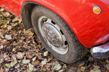 Front wheel and part of wing of old red car