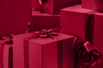 Gift boxes with a bow on a red background. Color of the year 2023 - Viva Magenta
