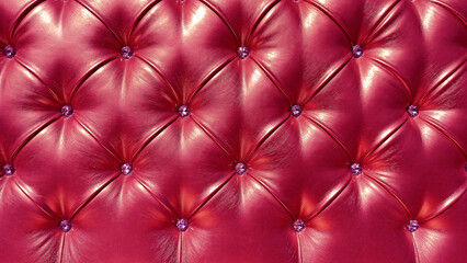 Trendy color of year 2023. Stylish soft leather upholstery of sofa in color Viva Magenta. The material is decorated with buttons in the form of crystals.