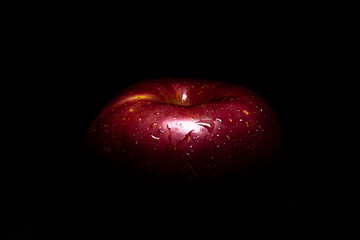 A fresh apple isolated in a black background.