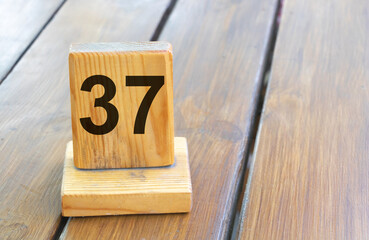 Wooden priority number 37 on a plank tab