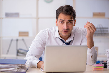 Young male employee and too much work in the office