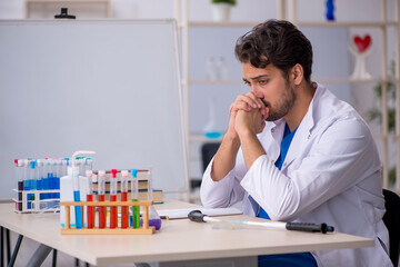 Young male chemist working at the lab