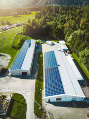 Vertical photo of two industrial buildings with a roof covered in solar panels - renewable energy  © VisualProduction