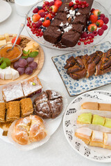 The view from above for a festive table with a chocolate cake, fresh blueberries, raspberries, strawberries, red currants and other sweets. Festive concept