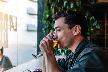 Man speaking on mobile phone and drinking beer