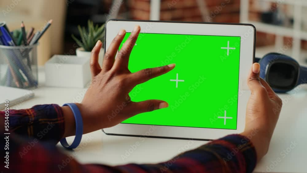 Poster office employee using horizontal greenscreen on wireless device, looking at blank chroma key templat