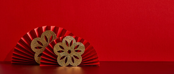 Happy Chinese New Year 2023 year of the rabbit concept. Red paper fans with gold flowers on red...