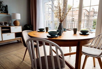 Wooden table with chairs in the living room. Stylish modern interior in Scandinavian style.