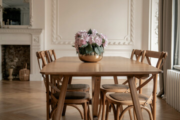 Wooden table with chairs in the living room. Stylish modern interior in Scandinavian style.
