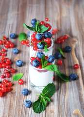 Obraz na płótnie Canvas white yogurt with fresh berries in glass jar, on wooden background.