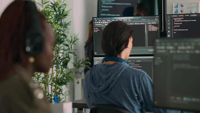 Database programer writing code on terminal window using multiple monitors in it agency office. System software developer typing database information, computing big data script.