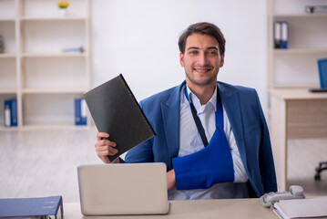 Young male employee after car accident at workplace