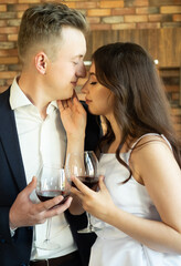 Young newlywed couple drinking wine and smiling at their happiness, romance and tenderness
