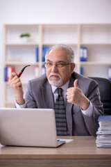 Old male employee working in the office