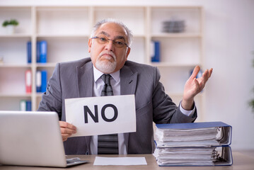 Old male employee working in the office