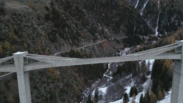 Large bridge in winter with a forest in the background in autumn colors. The mountains are covered with snow. Ganterbr&uuml;cke. Aerial Shot