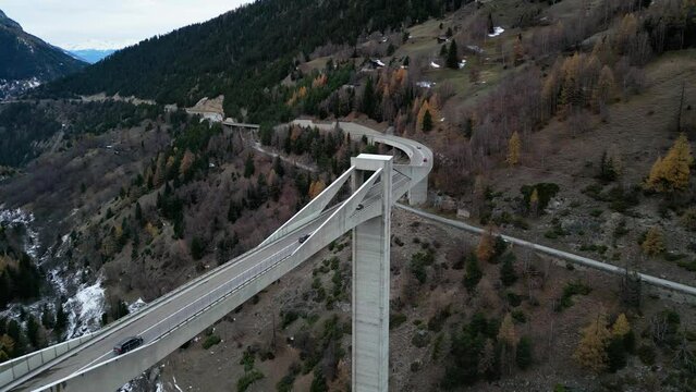Cars drive over a bridge in the mountains. The bridge connects the valley. It is the Simplon Pass in Switzerland. Ganter bridge. Aerial Shot