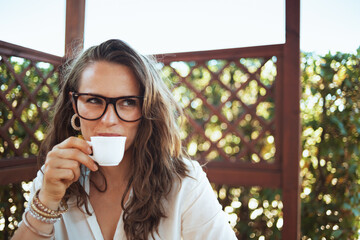 happy woman in white shirt drinking coffee