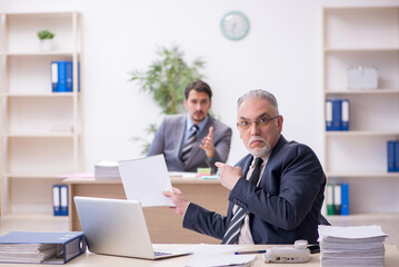 Two male employees working in the office