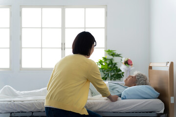 高齢者を看病する女性　介護疲れ