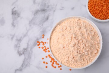 Lentil flour and seeds on white marble table, flat lay. Space for text