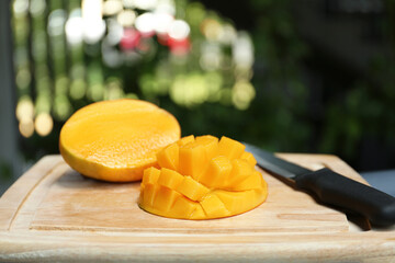 Cut ripe juicy mango on wooden board