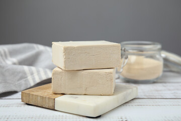Blocks of compressed yeast on white wooden table, closeup