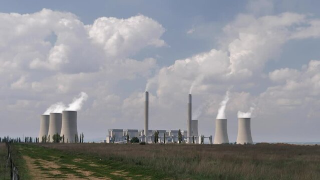 Clouds of steam rise from six cooling towers at coal fired power plant