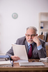 Fototapeta premium Old male boss employee working in the office