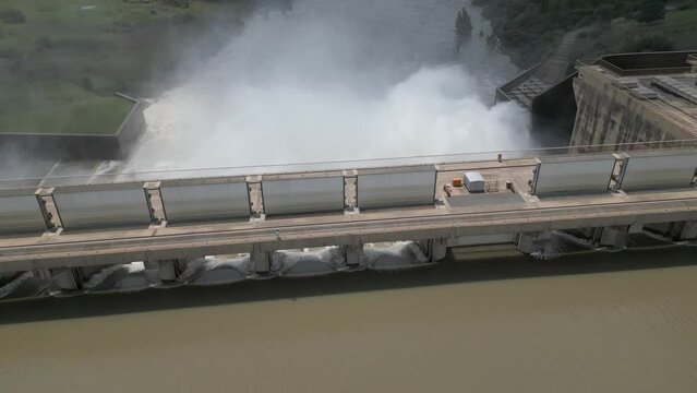 Aerial flyover reveals flood water being released from hydro power dam