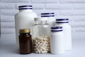 Different medical bottles on white wooden table