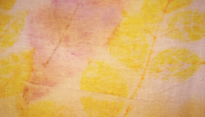 Texture and pattern of natural leaf in yellow ang pink color from eco print process.  Eco print on white fabric background. 