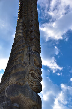 wooden tiki guardian carving with sky background