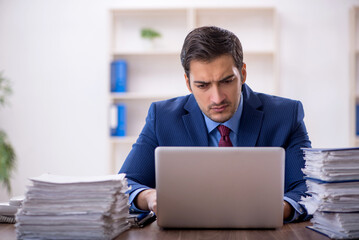 Young male employee and too much work in the office