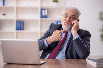 Old male boss employee working in the office