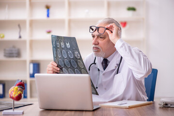 Old male doctor radiologist working in the clinic