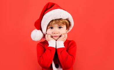 Cute child in in Santa Claus hat and costume celebrating Christmas. New Year holidays.