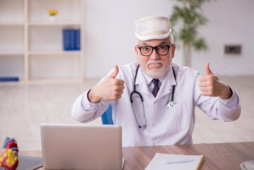 Old male doctor holding neck brace at the hospital