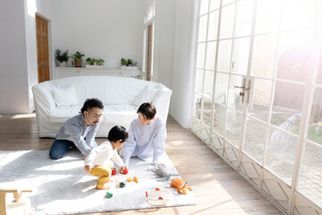 リビングで幼児と遊ぶ仲良しファミリー 広角　やや俯瞰