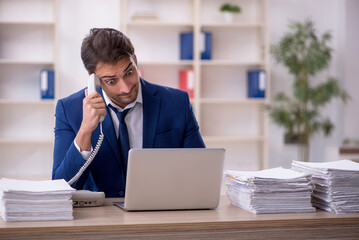 Young male employee and too much work in the office