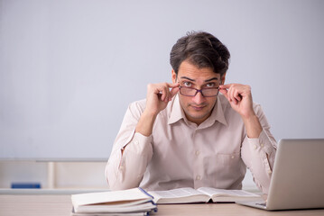 Young male teacher student sitting in the classroom